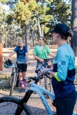 Mountain bike coaching group riding on forest trail