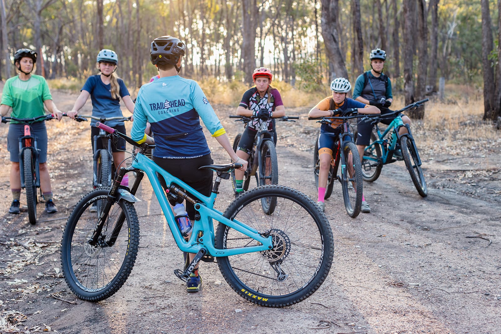 Mountain biker riding on forest trail during coaching session