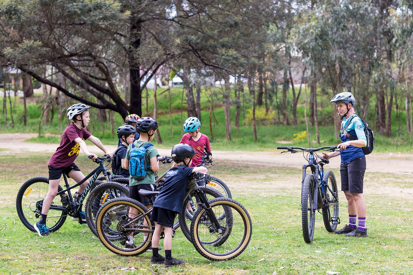 Trail Head Coaching Mountain biker riding on forest trail during coaching session