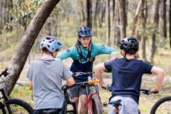 Mountain biker riding on forest trail during coaching session