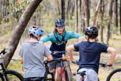 Mountain biker riding on forest trail during coaching session